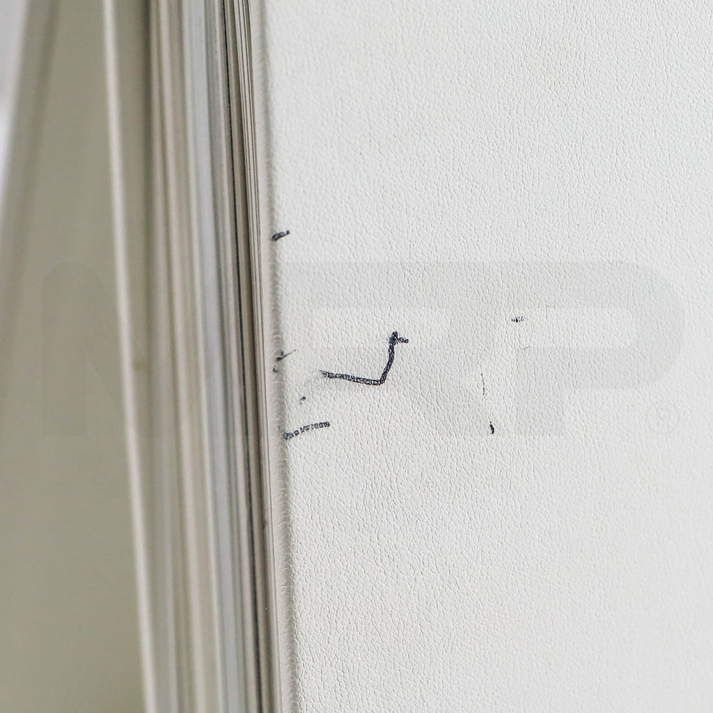 Close-up of minor pen marks on Sciton binder cover near spine