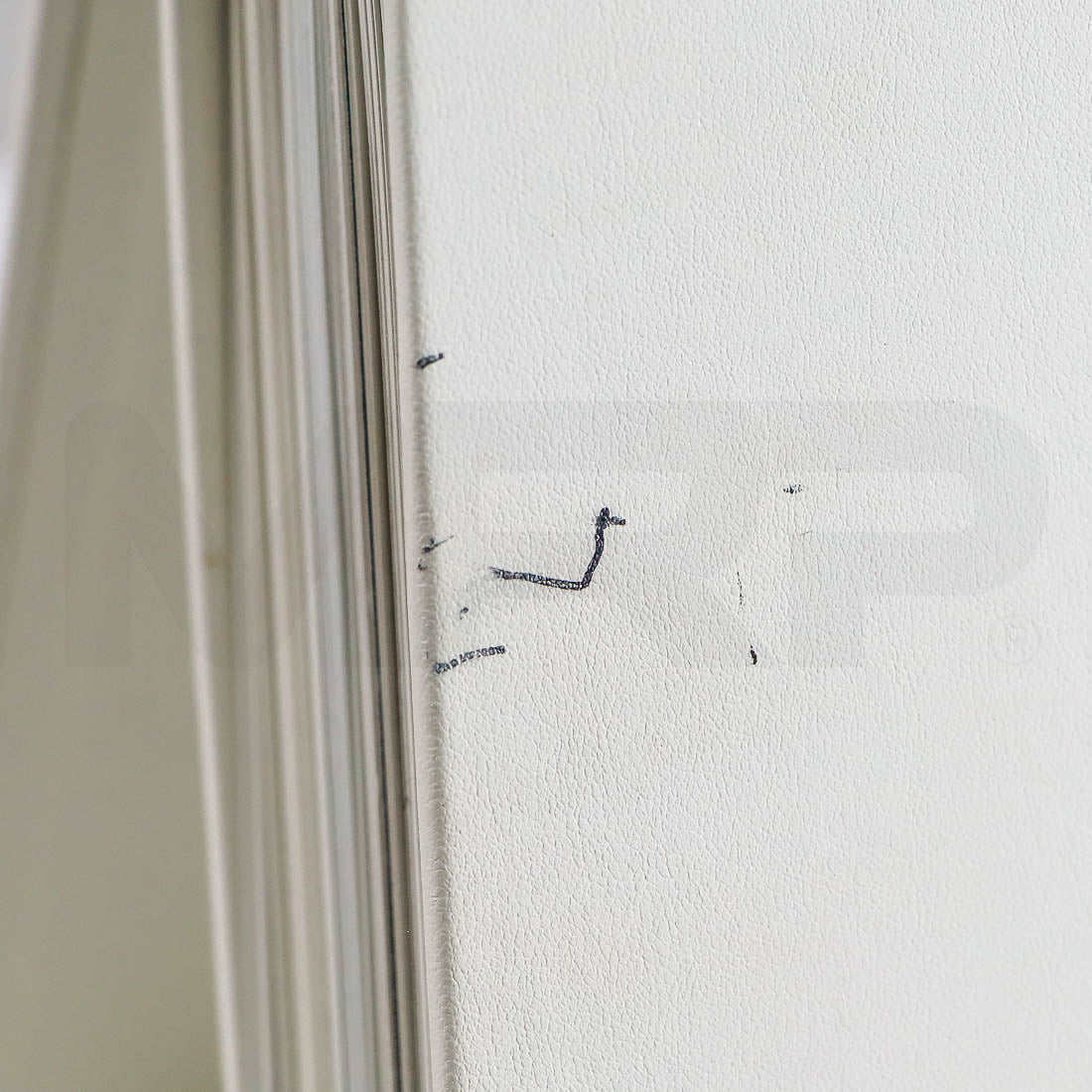 Close-up of minor pen marks on Sciton binder cover near spine